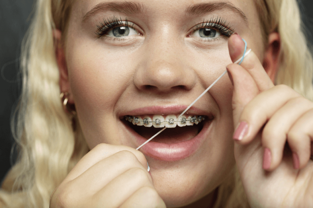 Girl with braces flossing