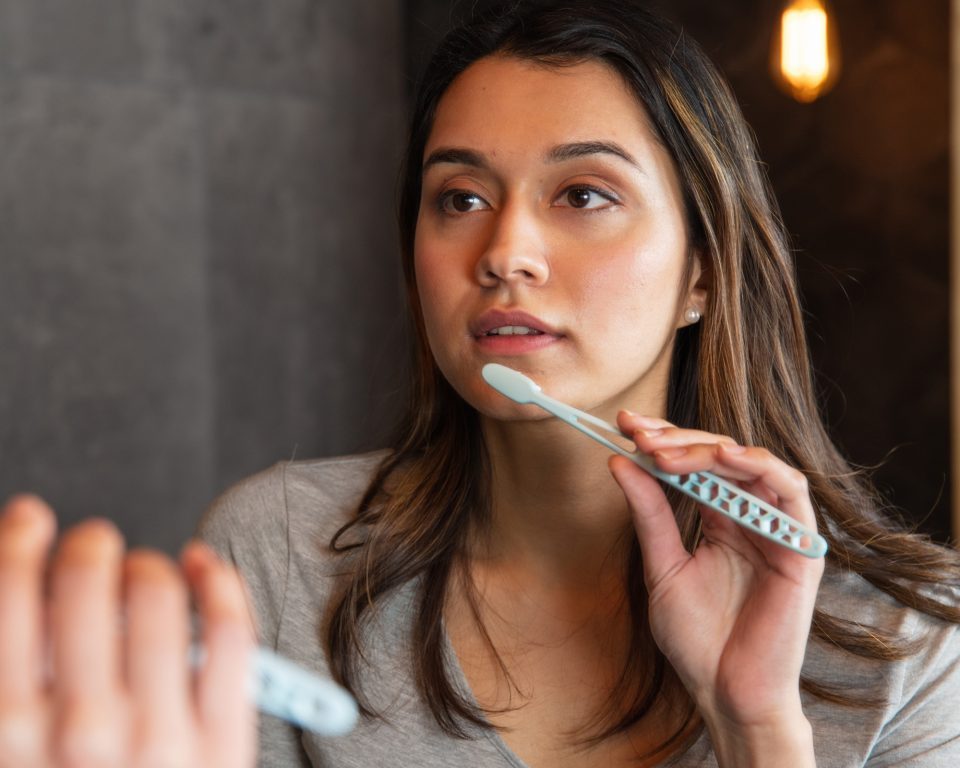 woman brushing and looking into mirror