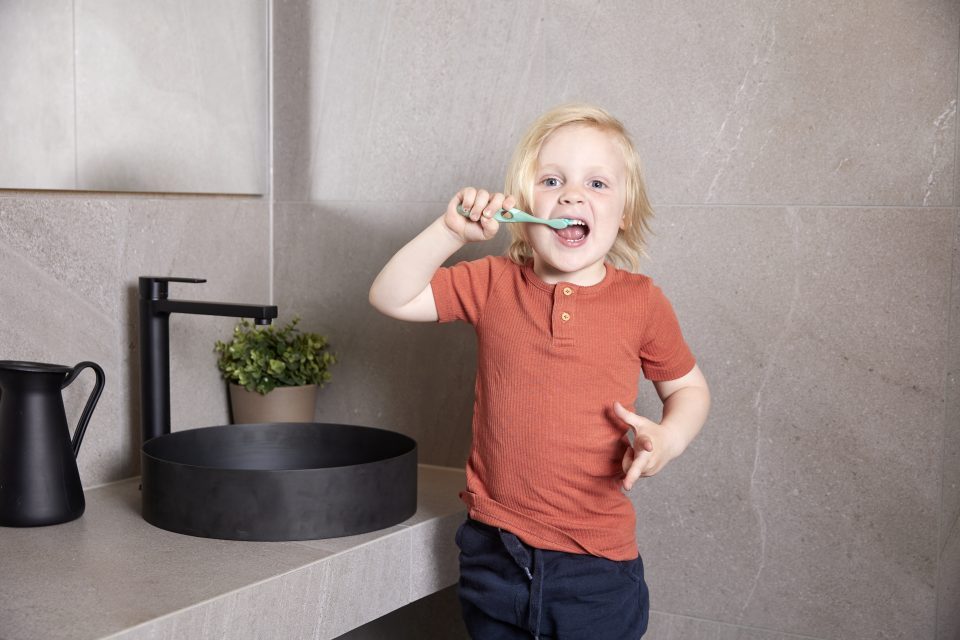 child brushing teeth in bathroom