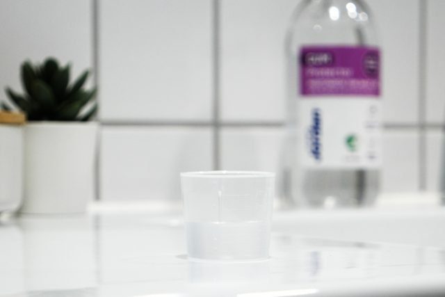 Bild som föreställer plastkopp som står på ett handfat i badrummet. I bakgrunden står en Jordan munskölj