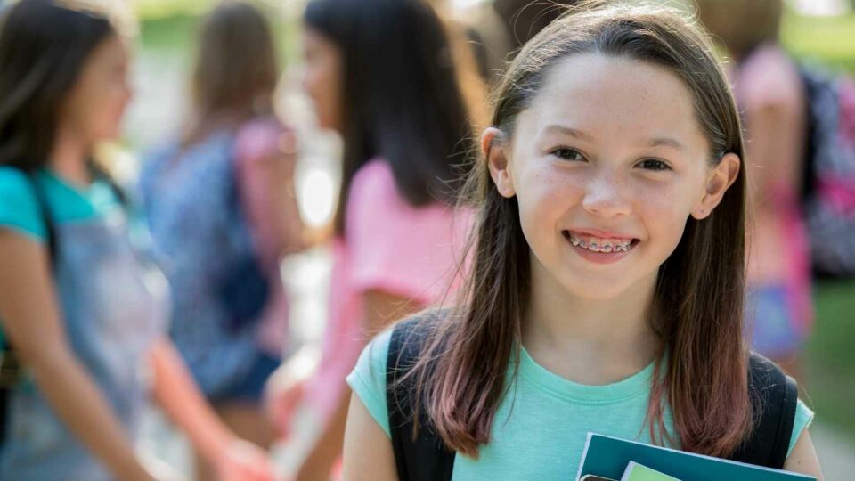 Adolescente con apparecchio sorridente a scuola